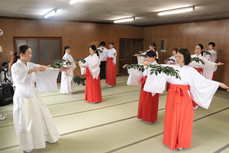 指導を受けながら巫女舞の練習に励む参加者＝岡山県津山市で