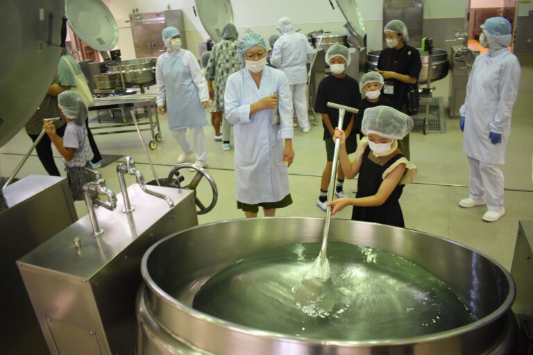 釜を混ぜる体験をする子どもたち=岡山県津山市で