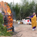 燃える火の中に位はいなどを入れる滋澤住職