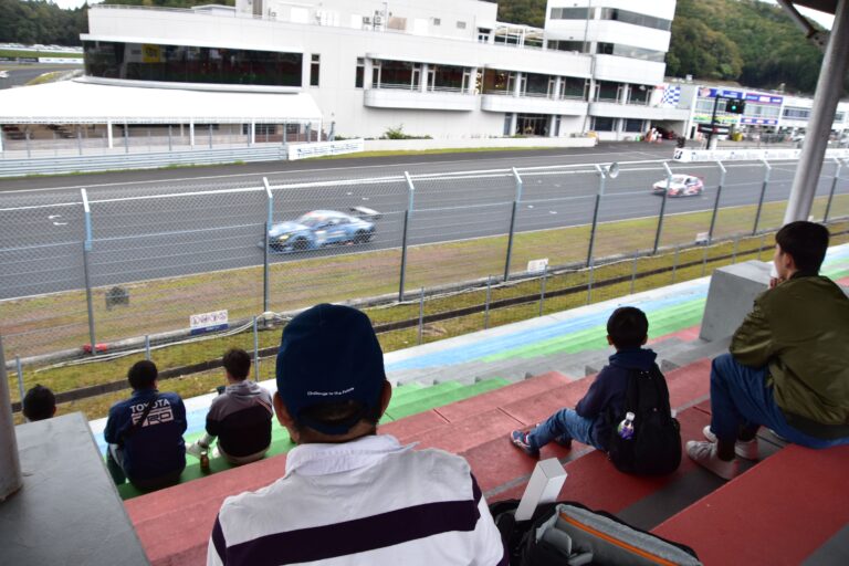 さっそうと走り抜ける車に見入る来場者＝岡山県美作市で