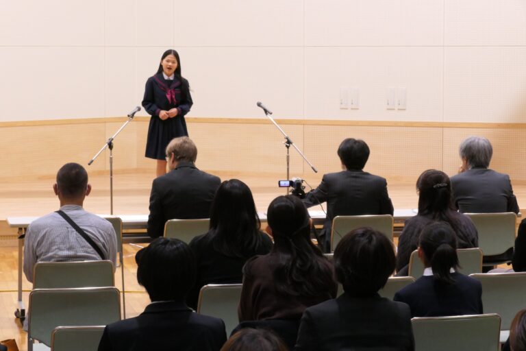 聴衆の前で発表する中学生たち