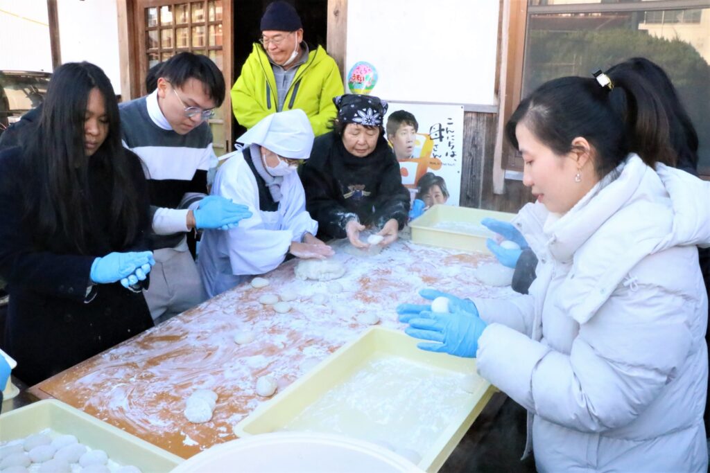 ついた餅を丸める参加者