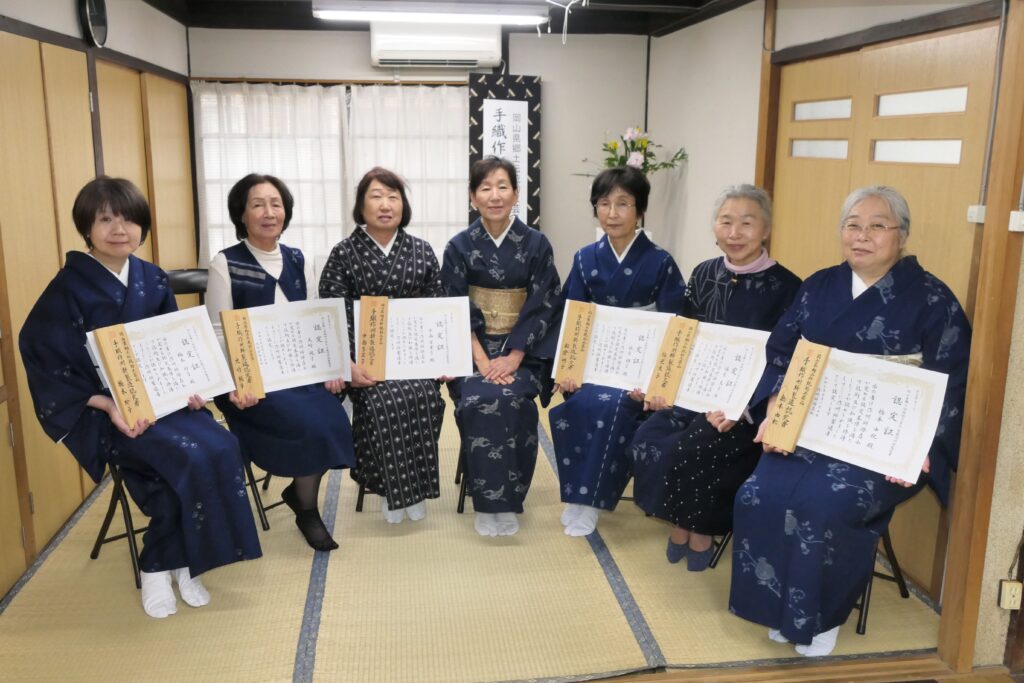 今回認定を受けた６人と日名川会長（中央）