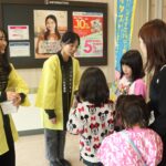 買い物客に啓発グッズを配布する学生=岡山県津山市で