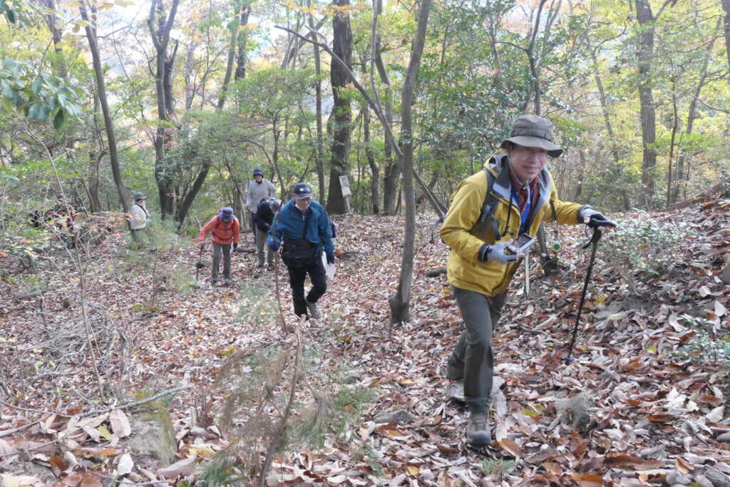 山中の遺構を巡り、本丸跡を目指す参加者