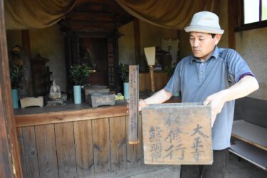 お堂で発見した「大正寺」と書かれた木の箱を手に持つ赤坂さん=岡山県津山市で