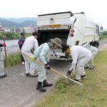 集めた雑草をパッカー車に入れる市民