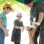 丸太切りを体験する子ども