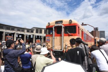 迫力の転車台実演にカメラを向ける来場者=岡山県津山市で