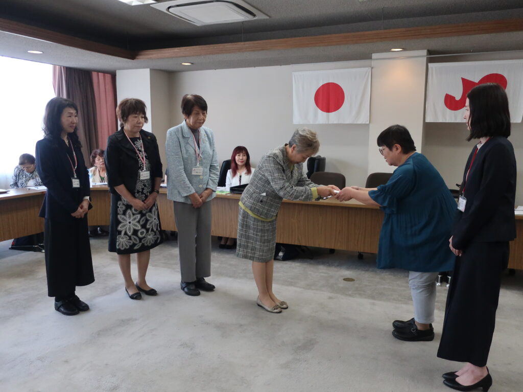 目録を手渡す野村会長（右から3番目）