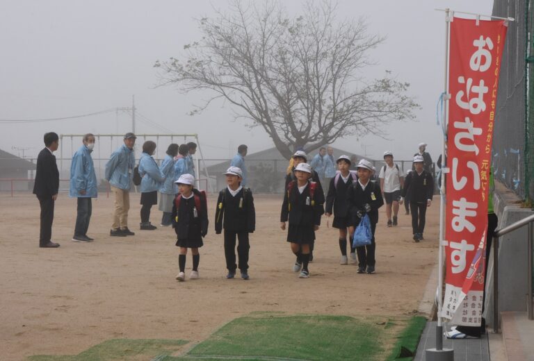 登校する児童にあいさつをする民生児童委員ら=岡山県津山市で