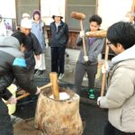 和気あいあいと餅をつき上げる留学生たち=岡山県津山市で