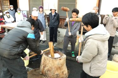 和気あいあいと餅をつき上げる留学生たち=岡山県津山市で