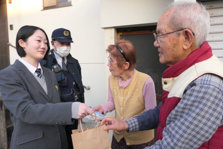 お年寄りにプレゼントを手渡す高校生=岡山県津山市で