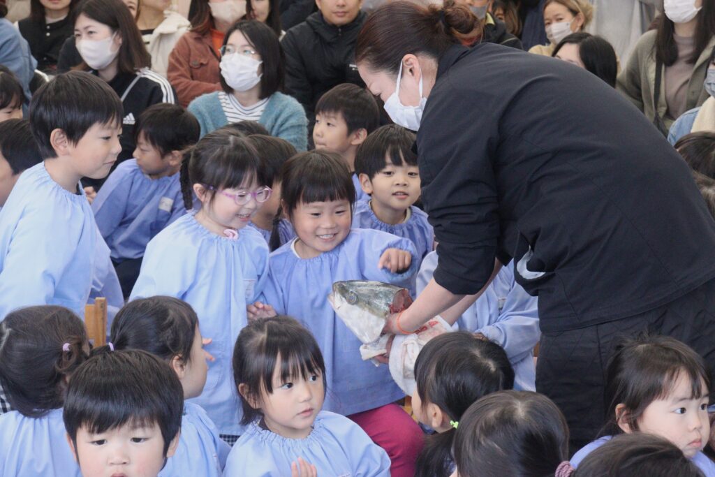 ブリの感触を楽しむ園児たち