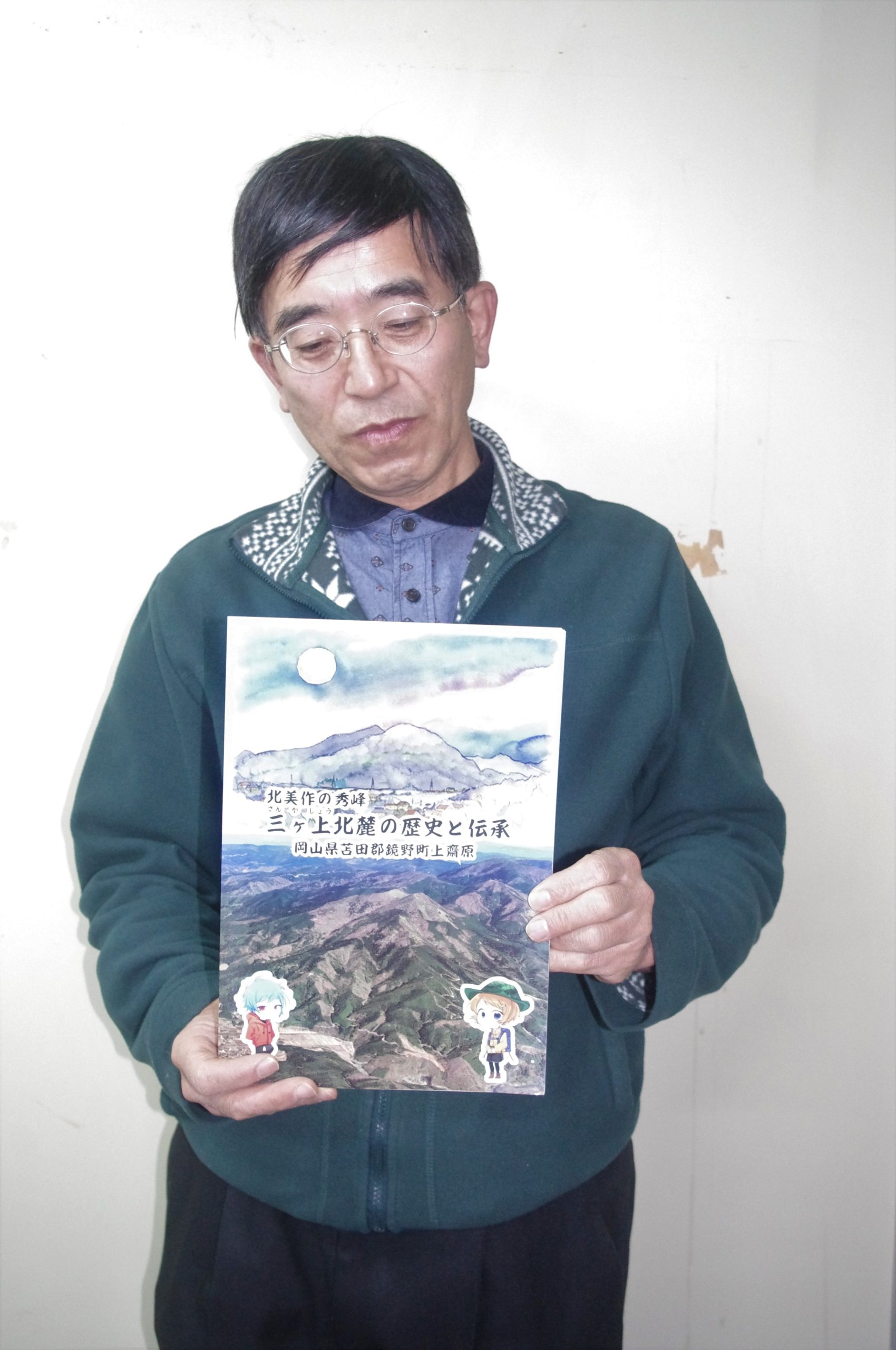 　自費出版した冊子『三ケ上北麓の歴史と伝承』を手にする片田さん