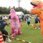 襲い掛かる恐竜から逃げる参加者=岡山県津山市で