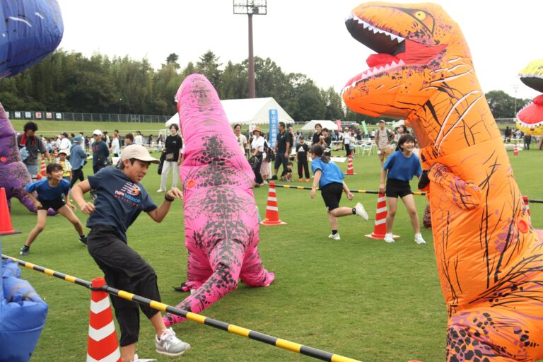 襲い掛かる恐竜から逃げる参加者=岡山県津山市で