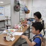 リサイクル品を使った 小物を観賞する子どもたち＝岡山県津山市で