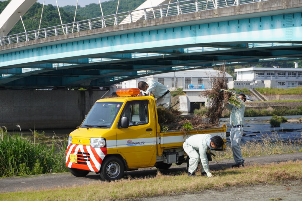 集めたごみをトラックに乗せる市民