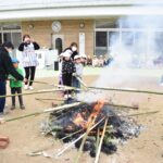 竹に挟んだ餅を焼く子どもたち=岡山県津山市の城西保育園で