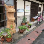 町家の前で植木鉢と一緒に展示された彫刻=岡山県津山市で