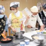 食育講座で高齢者の調理をサポートする学生たち=岡山県真庭市で