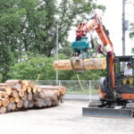 林業機械を操作し、丸太をつかむ作業を体験する参加者