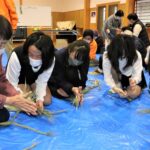 中島千恵子さんに教わりながらしめ飾りを作る児童たち＝岡山県津山市で