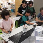 プログラムを組み、小型ロボットの操作に挑戦する子どもたち＝岡山県津山市で