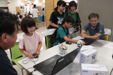 プログラムを組み、小型ロボットの操作に挑戦する子どもたち＝岡山県津山市で