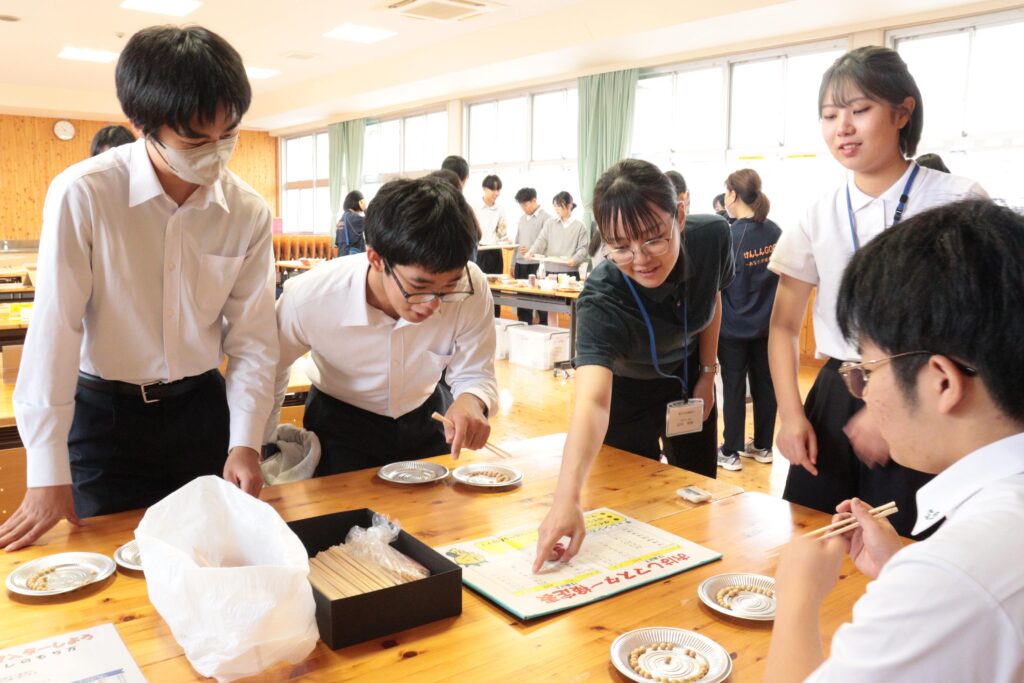 大豆を箸でつまんで運ぶゲームを楽しむ生徒