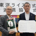 包括連携協定を締結し、協定書を手にする東洋ライスの阪本哲生社長（右）と太田昇真庭市長＝岡山県真庭市で