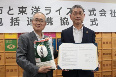 包括連携協定を締結し、協定書を手にする東洋ライスの阪本哲生社長（右）と太田昇真庭市長＝岡山県真庭市で