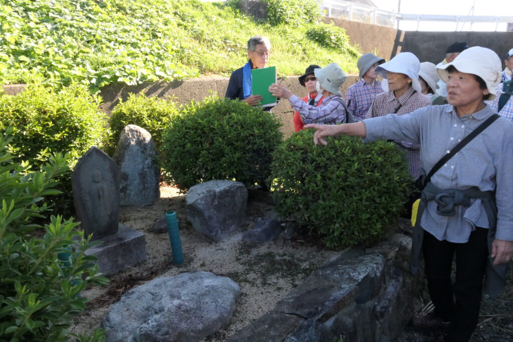 新野小学校敷地内の石碑について知識を深める参加者