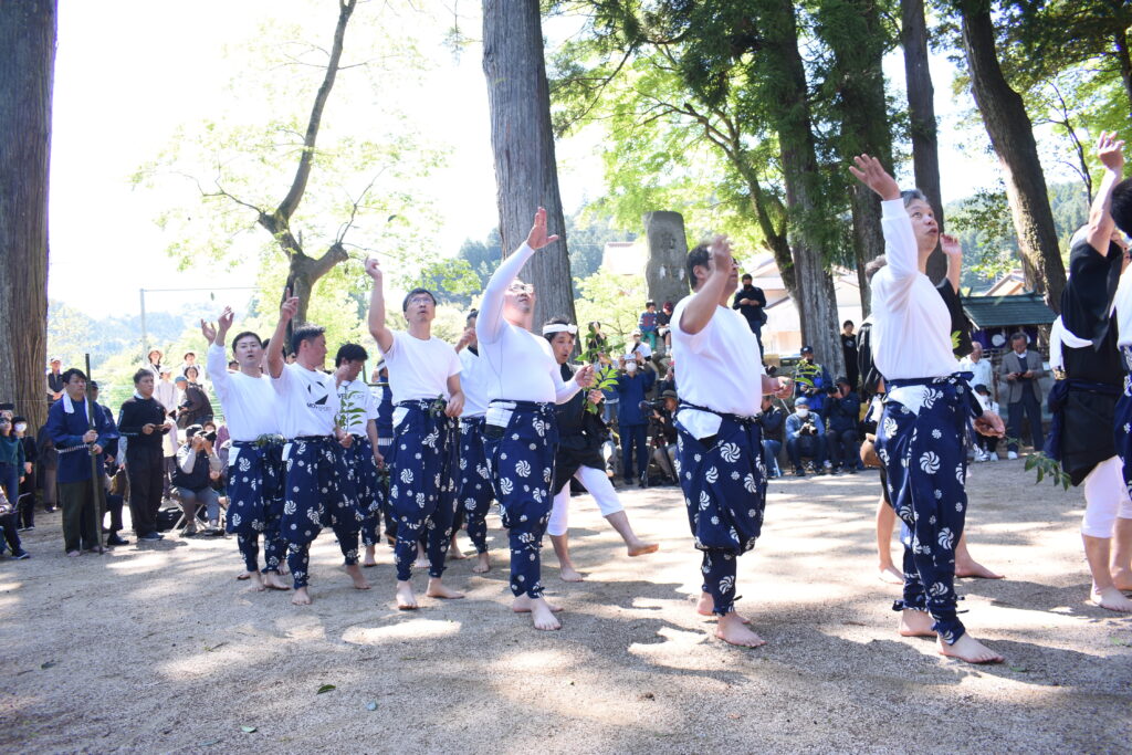 「田植」でサカキの葉をまく男衆