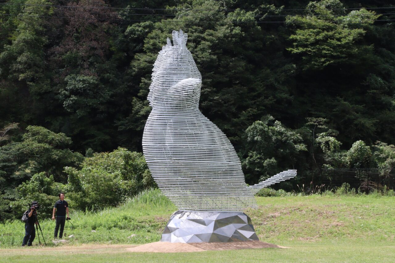 芝生広場でお披露目された半透明の巨大な鳥の作品「山に響くこだま」=2024年9月4日、鏡野町で