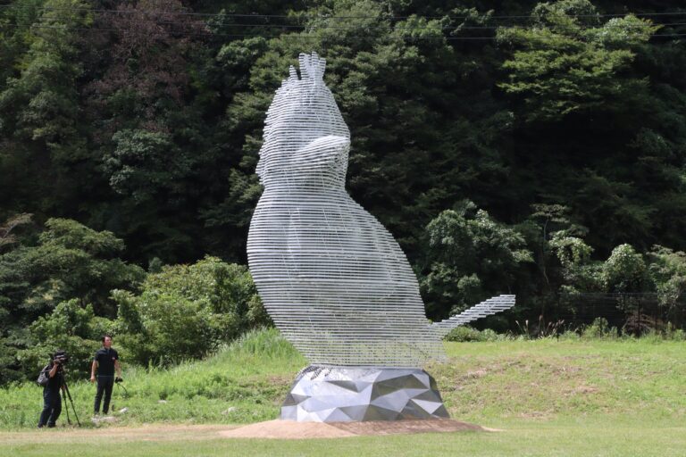 芝生広場でお披露目された半透明の巨大な鳥の作品「山に響くこだま」=2024年9月4日、鏡野町で