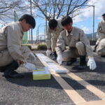 駐車場の白線引きに取り組む高校生=岡山県津山市で