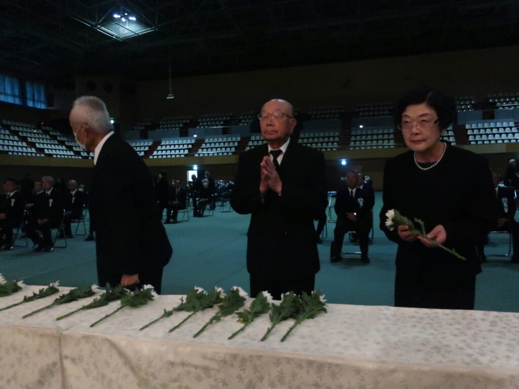 献花台に白菊をたむける参列者