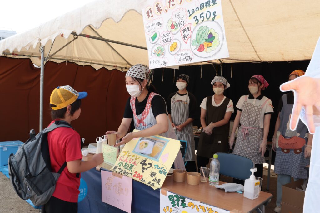 オリジナルドーナツ、コーラを販売する栄養学科の学生