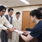 目録を手渡す伊藤工場長ら