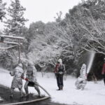 雪が降る中、消火訓練を行う消防団員=岡山県津山市で