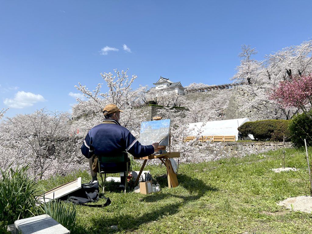 桜咲く津山城を描く男性＝2023年3月28日 午後11時54分