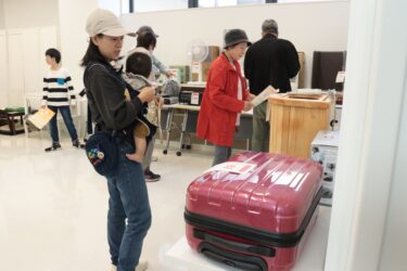 抽選に申し込むリユース品を品定めする来場者=岡山県津山市で