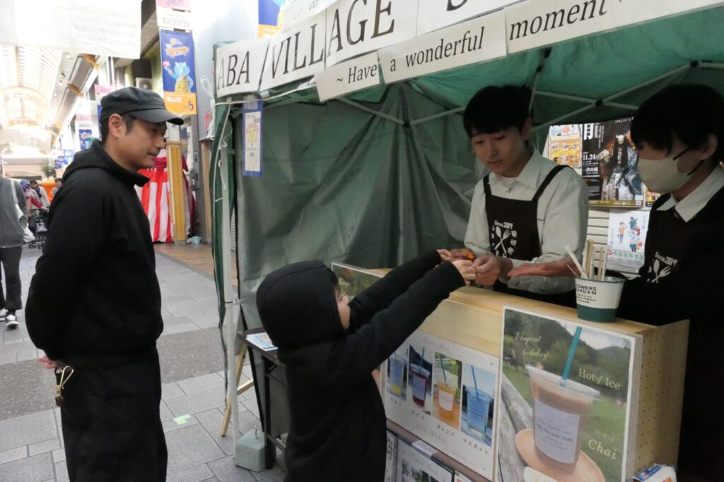 店の手伝いに励む高校生たち