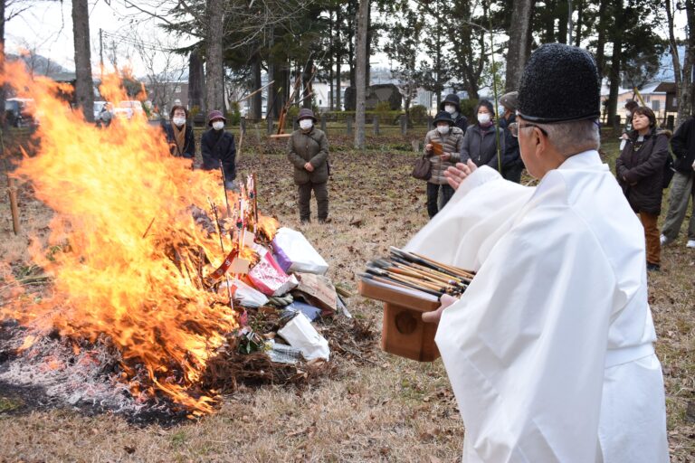 炎の中に古筆を投げ入れる小坂宮司=岡山県津山市で