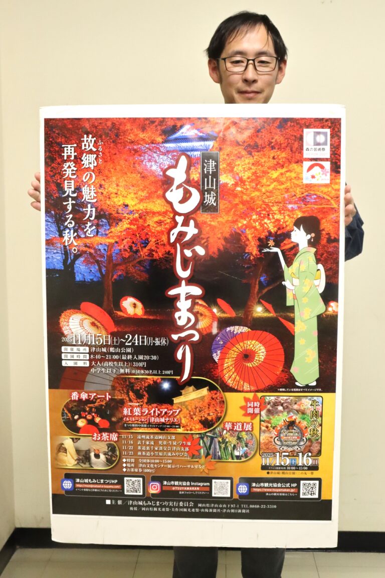 「津山城もみじまつり」のポスターを手にPRする市観光協会の職員=岡山県津山市で