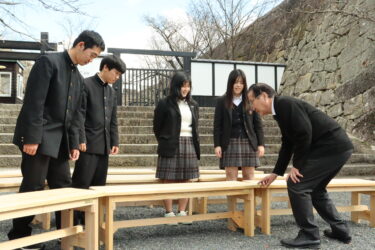 ベンチを製作した高校生たちと河本観光協会長=岡山県津山市で