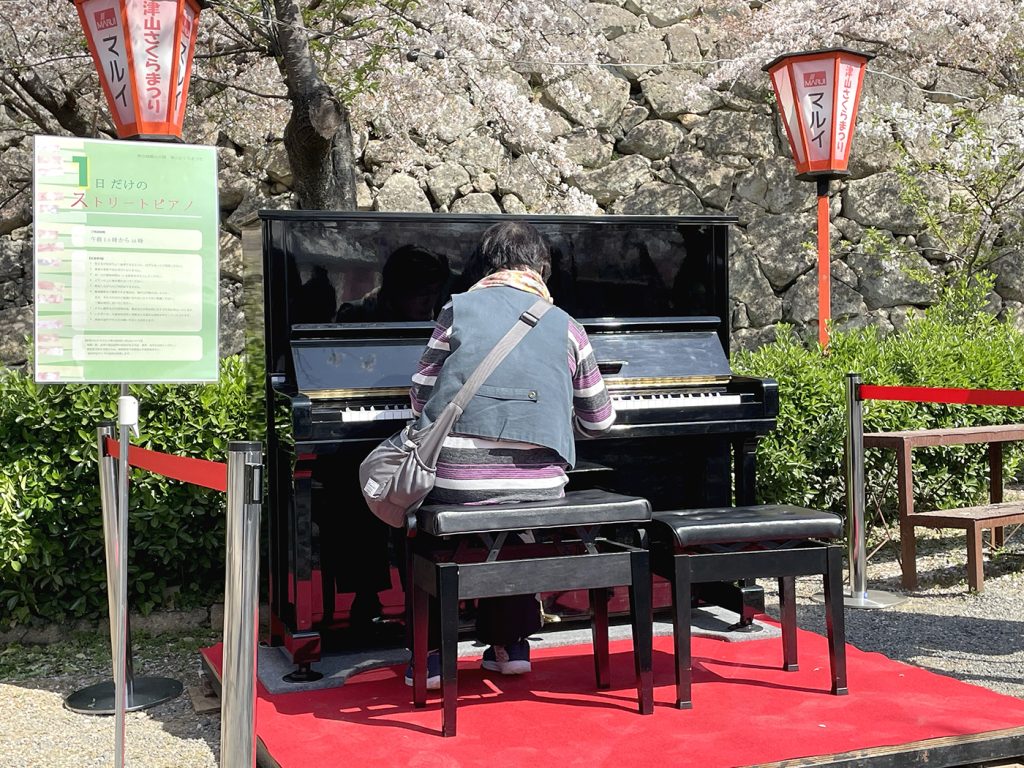 周囲の雰囲気を盛り上げてくれるストリートピアノの演奏者=2023年4月3日午前9時36分